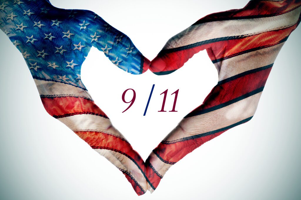 American flag hands in a heart shape with 9/11 text, symbolizing remembrance and unity.