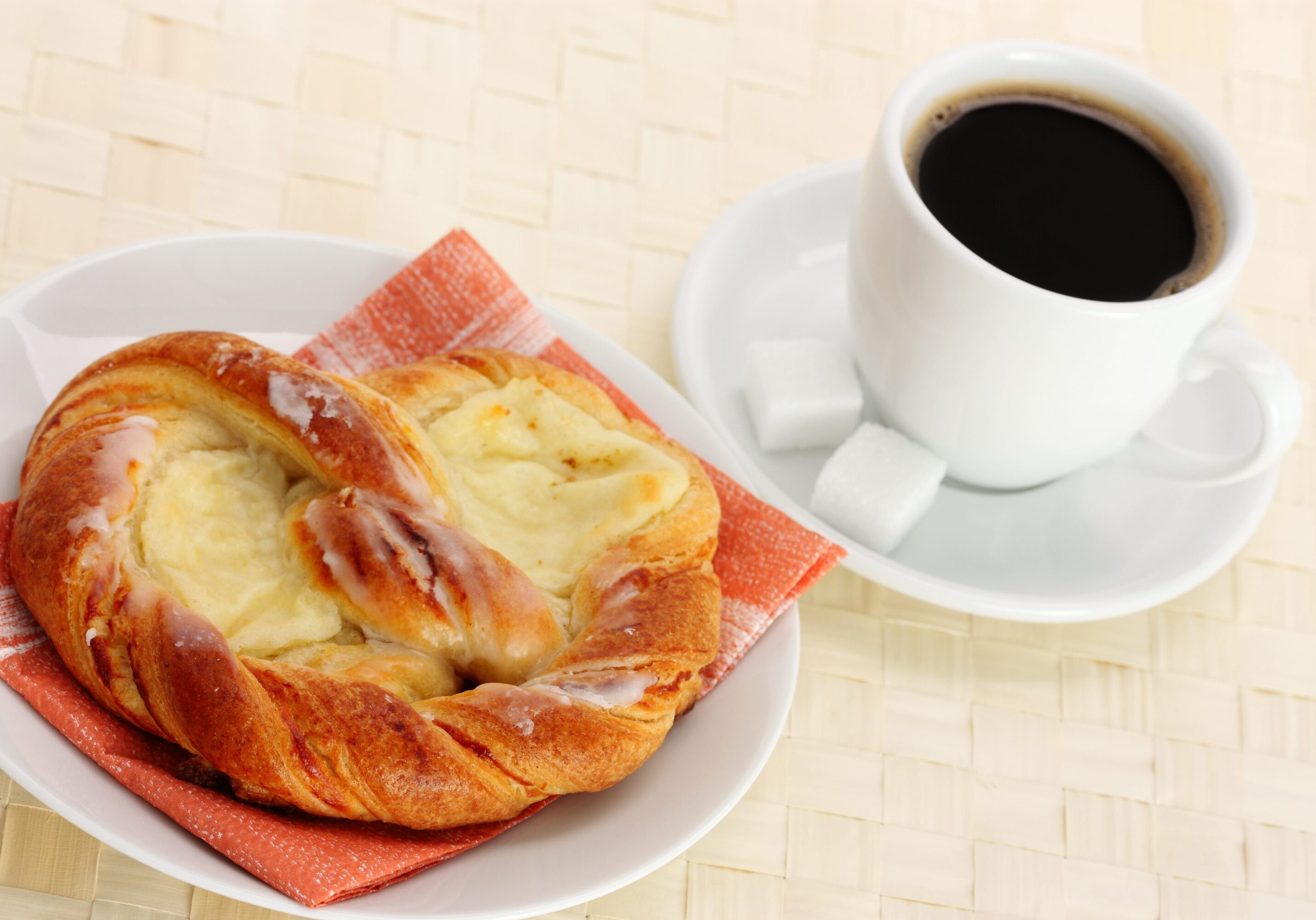 Freshly brewed coffee with sweet pastry on a breakfast table.
