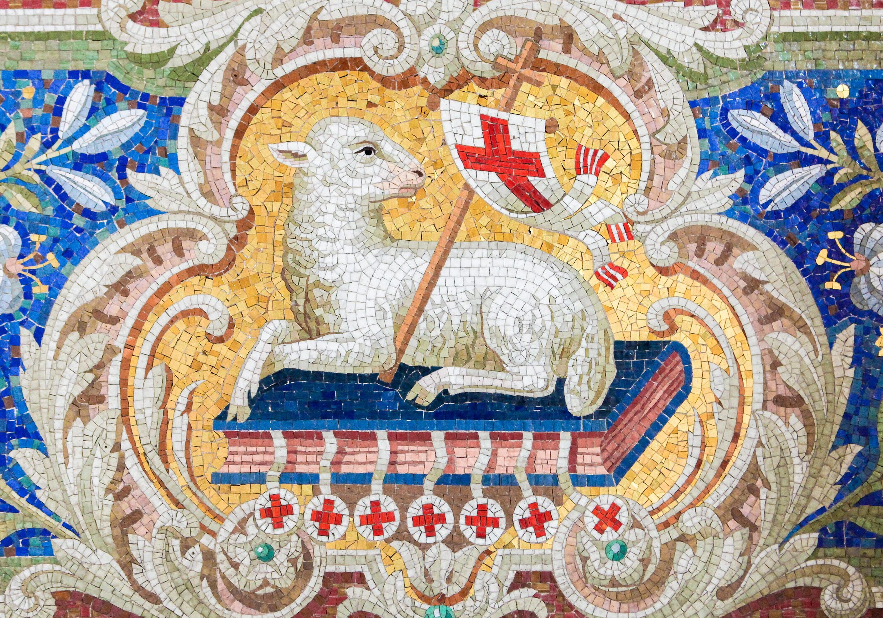 Mosaic of a lamb holding a cross banner.
